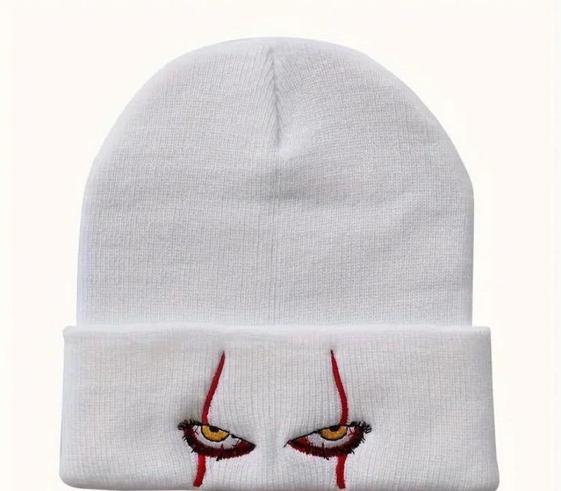 May include: White knit beanie with red embroidered eyes and blood dripping down the sides.