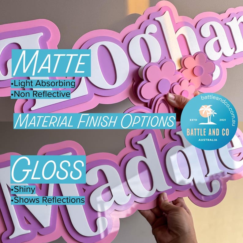 May include: A layered custom name sign featuring pink and purple tones with white lettering. The top section displays a matte finish with light-absorbing properties, while the bottom section shows a gloss finish that reflects light. Includes floral accents.