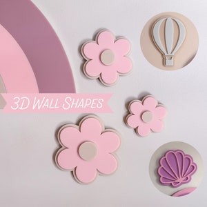 May include: A selection of 3D wall shapes in pastel shades. The shapes include flowers, a hot air balloon, a seashell, and a rainbow. The flowers are pink with a light beige centre and outline. The text "3D WALL SHAPES" is displayed in a banner.