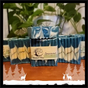 May include: A stack of blue and white marbled soap bars with a label that reads "Spearmint Baker's Tree".