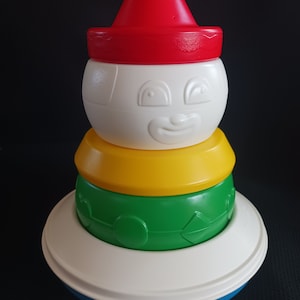 Tupperware vintage Roly Poly apilable con forma de payaso, anillos blancos, verdes, amarillos y azules, sombrero rojo