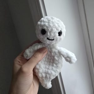 May include: White crocheted ghost plush toy with black eyes and a smiling mouth.