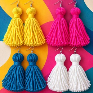 May include: Four pairs of dangling tassel earrings made from thick cotton cord. The set includes one pair of bright yellow, one pair of vibrant hot pink, one pair of deep teal, and one pair of crisp white earrings, each with silver-toned hooks.