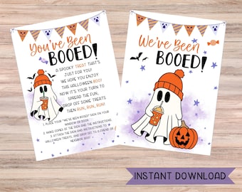 May include: Two Halloween-themed printable signs with the text "You've Been BOOED!" and "We've Been BOOED!". Each sign features a cartoon ghost wearing an orange beanie and holding a drink, with a pumpkin on one sign. The words "Instant Download" are also visible.