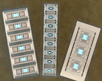 May include: Three rectangular circuit boards with copper traces and blue microchips. The boards are of varying sizes and are arranged on a brown surface. The boards have a clear protective coating.