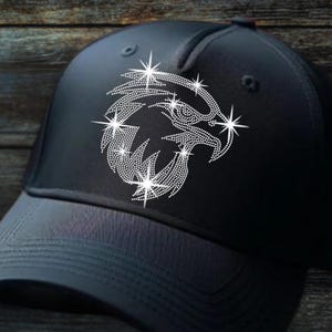 Op de afbeelding: Zwarte baseballcap met een strass adelaarsontwerp. De adelaar is versierd met sprankelende steraccenten. De cap heeft een gebogen klep en een gestructureerde kroon, geschikt voor casual gebruik.