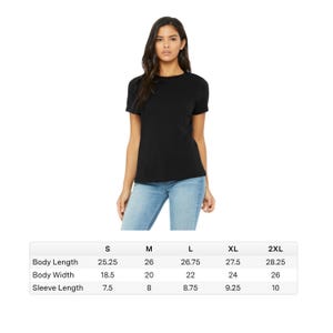 May include: A black short-sleeved t-shirt. The image includes a size chart with measurements for body length, body width, and sleeve length in inches for sizes S, M, L, XL, and 2XL. The model is wearing blue jeans.