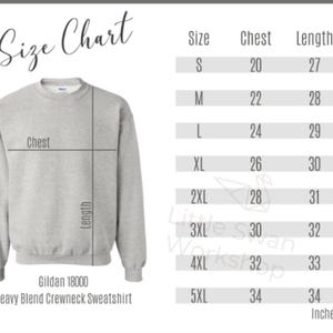 Op de afbeelding: Een lichtgrijs Gildan 18000 heavy blend sweatshirt met ronde hals naast een maattabel. De tabel toont de maten S tot 5XL met bijbehorende borst- en lengtematen in inches, vari&euml;rend van 20 tot 34 inch voor de borst en 27 tot 34 inch voor de lengte.