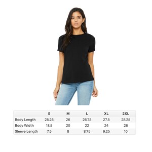 Peut inclure: Un t-shirt noir &agrave; col rond et &agrave; manches courtes. Le t-shirt est port&eacute; par une personne en jean bleu. Des mesures sont fournies pour la longueur du corps, la largeur du corps et la longueur des manches en cm pour les tailles S, M, L, XL et 2XL.