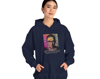 Puede incluir: Sudadera con capucha azul marino con un retrato de Ruth Bader Ginsburg. La imagen incluye texto colorido y la cita: "Lucha por las cosas que te importan, pero hazlo de una manera que lleve a otros a unirse a ti."