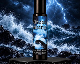 May include: A cylindrical perfume oil bottle with a black cap and a label featuring a stormy ocean scene with lightning. The label text reads Ocean Storm, 10 ml perfume oil, and Vampress Heart. The bottle stands on a black decorative base.