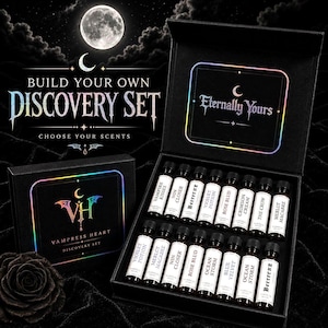 May include: A black discovery set box containing sixteen small glass vials with white labels, each printed with scent names like Vampire Kisses, Rose Blud, and Merlot Macabre. The box lid features the text Eternally Yours and Vampress Heart.