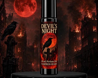 May include: A black rollerball bottle of perfume oil labelled DEVIL'S NIGHT and VAMPRESS HEART. The label features a red moon, a black raven perched on a cross, and flames. The bottle contains 10 mL of liquid and has a black cap.