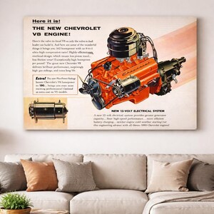 May include: A vintage advertisement for the new Chevrolet V8 engine. The image features a detailed illustration of the engine in orange and black, with text that reads "Here it is! THE NEW CHEVROLET V8 ENGINE!" and "NEW 12-VOLT ELECTRICAL SYSTEM."
