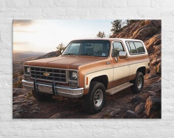 Puede incluir: Un SUV vintage marrón y crema está estacionado en una ladera rocosa. El vehículo tiene un diseño clásico con una parrilla y parachoques cromados. El fondo presenta una vista panorámica de montañas y una puesta de sol.