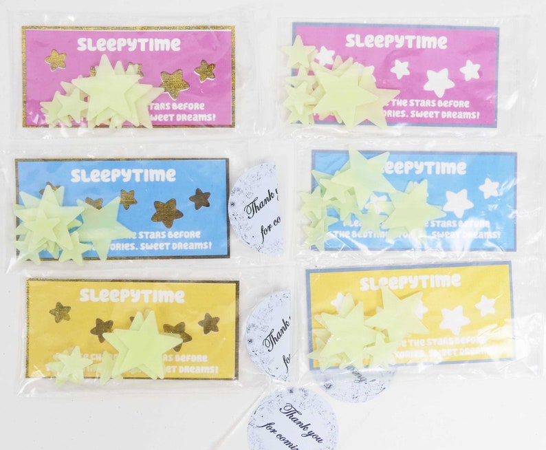 May include: Four packages of glow-in-the-dark star stickers. Each package has a blue, yellow, or pink background with the text "Sleepytime" and "The stars before stories, sweet dreams!" The packages are sealed in clear plastic.
