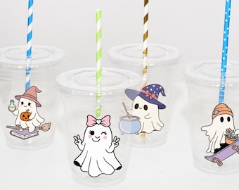 May include: Clear plastic cups with lids and colorful straws. Each cup features a different cartoon ghost illustration, including a witch, a ghost with a bow, and a ghost on a skateboard. The straws have blue, green, and gold stripes.