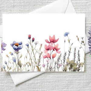 May include: A white greeting card with a watercolour floral design featuring pink, blue, and purple flowers. The card is on a white envelope. A sprig of lavender is in the background.