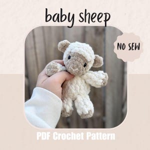 Puede incluir: Un juguete de oveja bebé de ganchillo en crema y marrón claro. La oveja tiene un cuerpo esponjoso, orejas pequeñas y una cara detallada. La imagen incluye el texto "baby sheep", "NO SEW" y "PDF Crochet Pattern".