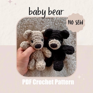 May include: Two crocheted baby bear toys, one beige and one black, are displayed. The bears have dark brown noses and are labeled "baby bear" and "NO SEW". The text "PDF Crochet Pattern" is also visible.
