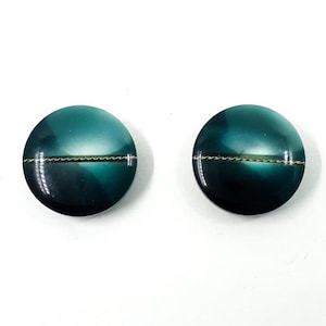 Può includere: Due bottoni rotondi di colore verde acqua con una sottile linea argentata al centro.