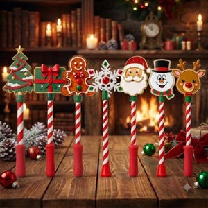 May include: A set of seven decorative Christmas-themed pens featuring toppers shaped like a green tree, a red gift box, a gingerbread person, a white snowflake, Santa Claus, a snowman, and a reindeer, all with red and white striped shafts.
