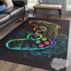 May include: Black rectangular area rug featuring a neon-colored video game controller design. The controller is outlined in vibrant rainbow hues, with buttons in red, pink, and green. The rug has a dark background with musical notes and symbols.