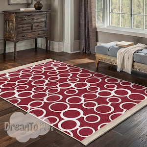 May include: A red and white area rug with a geometric pattern of overlapping circles. The rug has a cream-colored border.