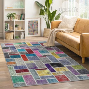 Puede incluir: Una alfombra de patchwork colorida con una variedad de colores y patrones, incluyendo rojo, azul, verde, amarillo y morado. La alfombra está hecha de materiales reciclados y tiene un aspecto desgastado.