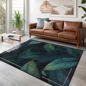 May include: A dark green and black area rug with a large leaf pattern. The rug has a gold border and is placed in front of a brown leather sofa.