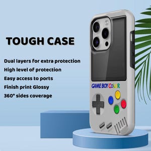 Może przedstawiać: Białe etui na telefon z retro wzorem Game Boy Color. Etui posiada czarny ekran, kolorowe przyciski oraz napis "GAME BOY COLOR". Tekst "TOUGH CASE" znajduje się na g&oacute;rze, z informacjami o ochronie.