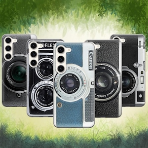 Può includere: Una collezione di cinque custodie per telefoni con design a tema fotocamera. Le custodie presentano vari design di obiettivi e corpi macchina, tra cui il marchio Canon. Le custodie sono nei colori nero, bianco e blu, con grafiche dettagliate di obiettivi e quadranti.