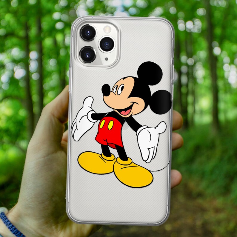 May include: A clear phone case with a black and white Mickey Mouse illustration. Mickey Mouse is wearing red shorts with two yellow buttons and yellow shoes. Mickey Mouse is smiling and has his arms outstretched.