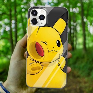 May include: A clear phone case with a yellow cartoon character with a winking face. The character is a Pikachu from the Pokemon franchise.
