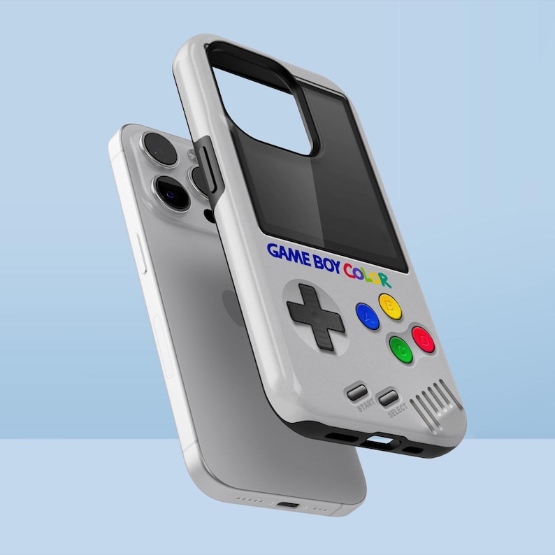Może przedstawiać: Białe etui na telefon zaprojektowane tak, aby przypominało Game Boy Color. Etui posiada czarny ekran, krzyżak i kolorowe przyciski. Na etui wydrukowano napis "GAME BOY COLOR".