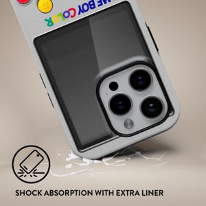 Może przedstawiać: Biało-szare etui na telefon z wzorem przypominającym Game Boy Color. Etui ma przezroczysty obszar ekranu i czarną obw&oacute;dkę obiektywu aparatu. Tekst "GAME BOY COLOR" jest wydrukowany na g&oacute;rze w tęczowych kolorach. Na dole znajduje się tekst "SHOCK ABSORPTION WITH EXTRA LINER".
