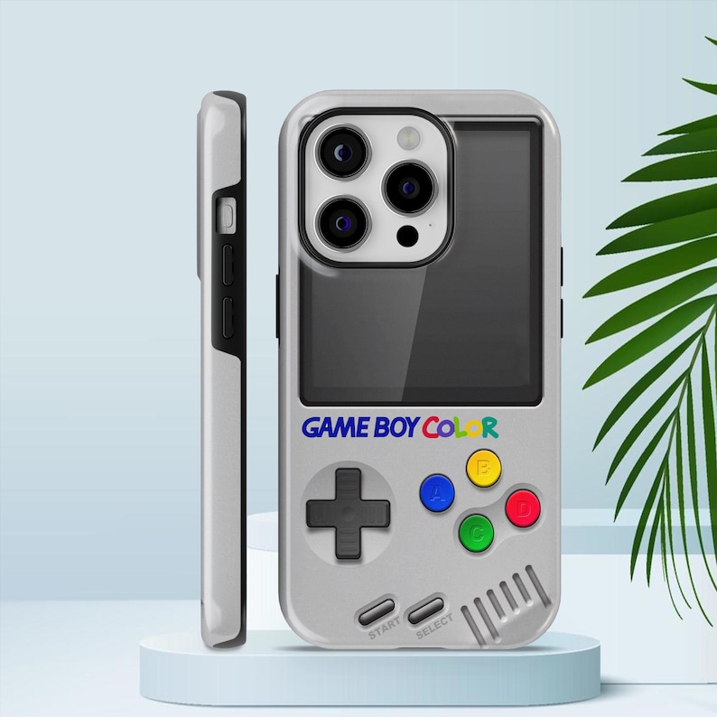 Może przedstawiać: Szara obudowa telefonu zaprojektowana tak, aby przypominała Game Boy Color. Obudowa posiada ekran, panel kierunkowy, kolorowe przyciski oraz tekst "GAME BOY COLOR" w kolorze niebieskim, ż&oacute;łtym, zielonym i czerwonym. Obudowa jest pokazana obok widoku z boku telefonu.