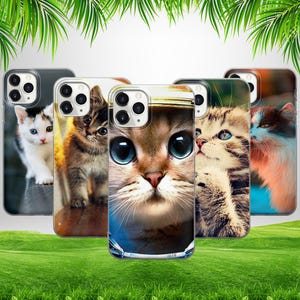 May include: Four different iPhone cases with cute cat designs. The cases are clear and show the phone's color through the design. The cats are a white cat with blue eyes, a brown tabby cat, a brown cat with big blue eyes, and a brown tabby cat with green eyes.
