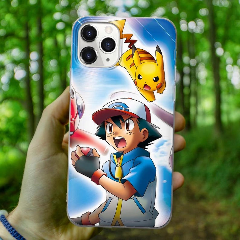 May include: A phone case with a cartoon image of a Pokemon trainer with a Pikachu on his shoulder. The trainer is wearing a blue and white shirt and a red hat. The background is blue and white.