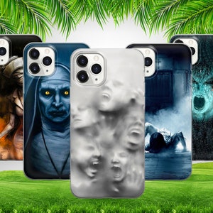 Pode incluir: Quatro capas de telefone diferentes com designs de terror. A primeira capa apresenta uma mulher com um vestido branco e uma faca ensanguentada. A segunda capa apresenta uma mulher com hábito de freira e um rosto assustador. A terceira capa apresenta um design branco com múltiplos rostos. A quarta capa apresenta um design azul e verde com o rosto de um monstro.