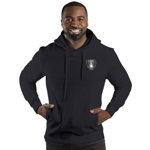 May include: Black hooded sweatshirt with a white graphic of a winged creature on the front.