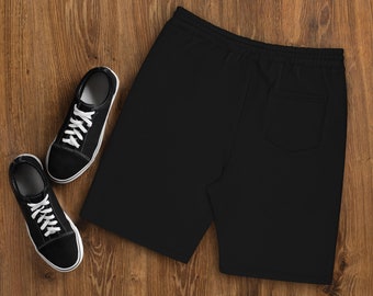 May include: Black sweat shorts with a drawstring waist and a back pocket. The shorts are laid flat on a wooden surface.