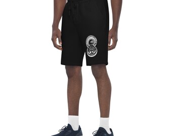 May include: Black shorts with a drawstring waist and a white graphic design. The design features a tree within a circular pattern. The shorts are made of a soft material and have pockets.