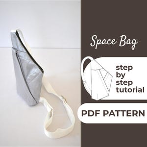 May include: A silver-colored sling bag with a white strap and a black zipper. The bag has a geometric design and the text "Space Bag" is visible. The image also includes the text "step by step tutorial" and "PDF PATTERN".