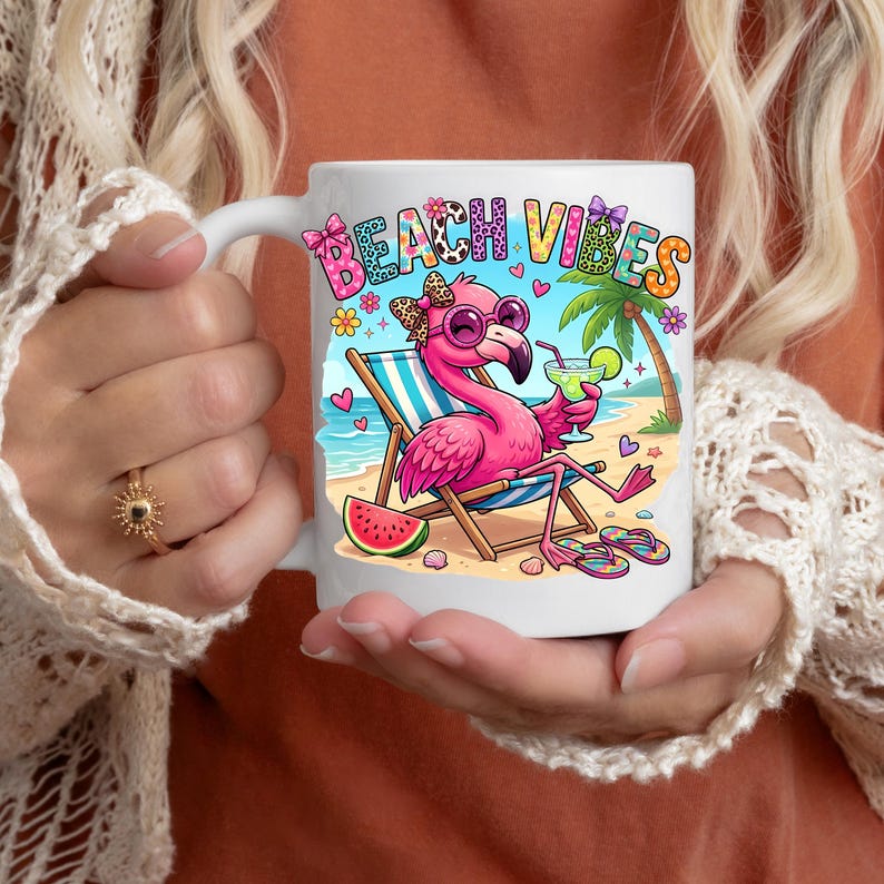 May include: White ceramic mug featuring a cartoon flamingo wearing sunglasses and holding a cocktail, with the words "BEACH VIBES". The flamingo is on a beach with a palm tree, watermelon, and flip-flops.