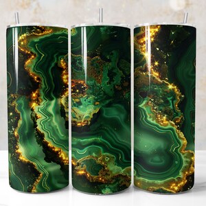 May include: Three stainless steel tumblers with a vibrant green and gold malachite design. The tumblers have a glossy finish and a straw. The design features swirling patterns and sparkling accents, creating a luxurious look.