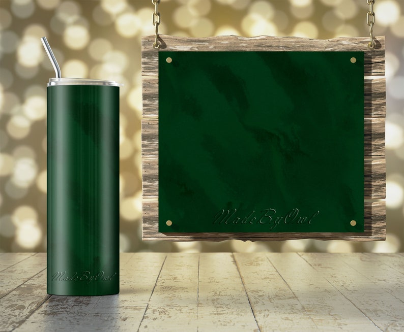 May include: A green stainless steel tumbler with a straw and the text "Made By Owl" on the side. The tumbler is sitting on a wooden surface in front of a green sign with the same text hanging from a chain.