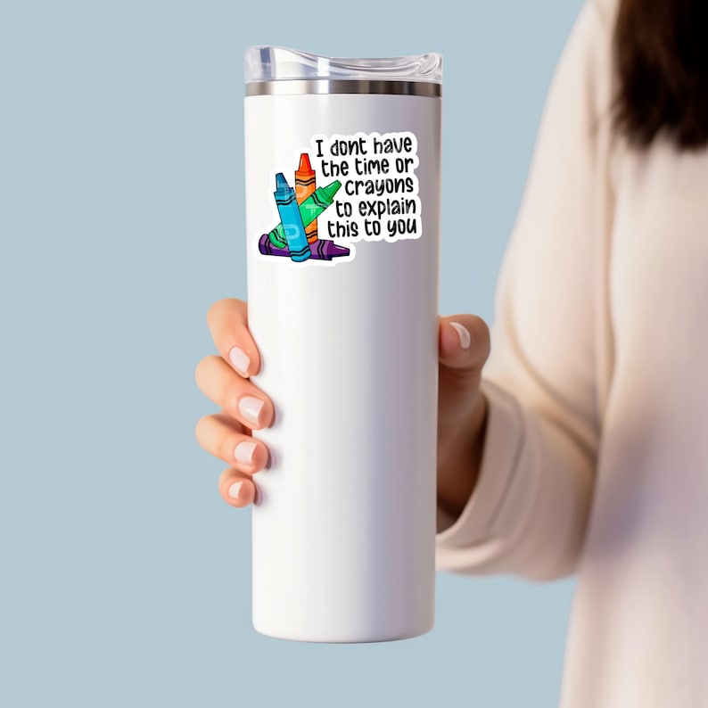May include: White stainless steel tumbler with a sticker that says "I don't have the time or the crayons to explain this to you". The sticker features a stack of colourful crayons.