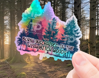May include: A holographic sticker with a colorful forest scene and the text "BORN AND RAISED IN THE WISHABITCH WOODS".