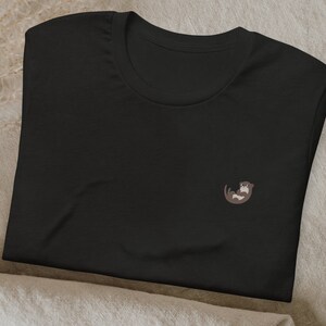 May include: Black t-shirt with a small embroidered otter design.